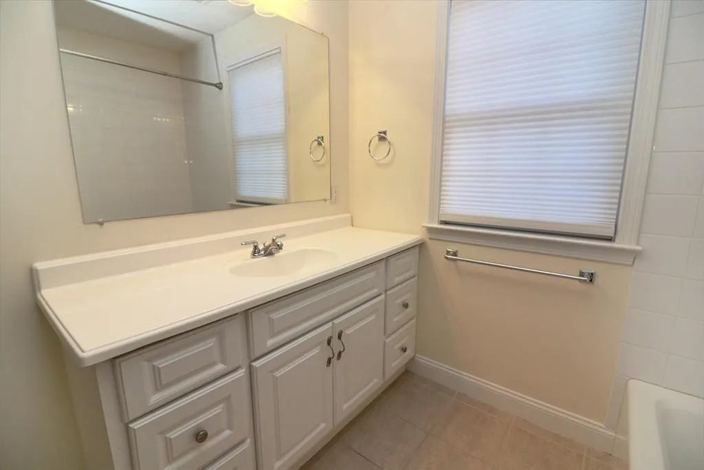 132 Howe Street, Unit B Natick, MA 01760 - Photo 24 of 32 a bathroom with a sink and a mirror