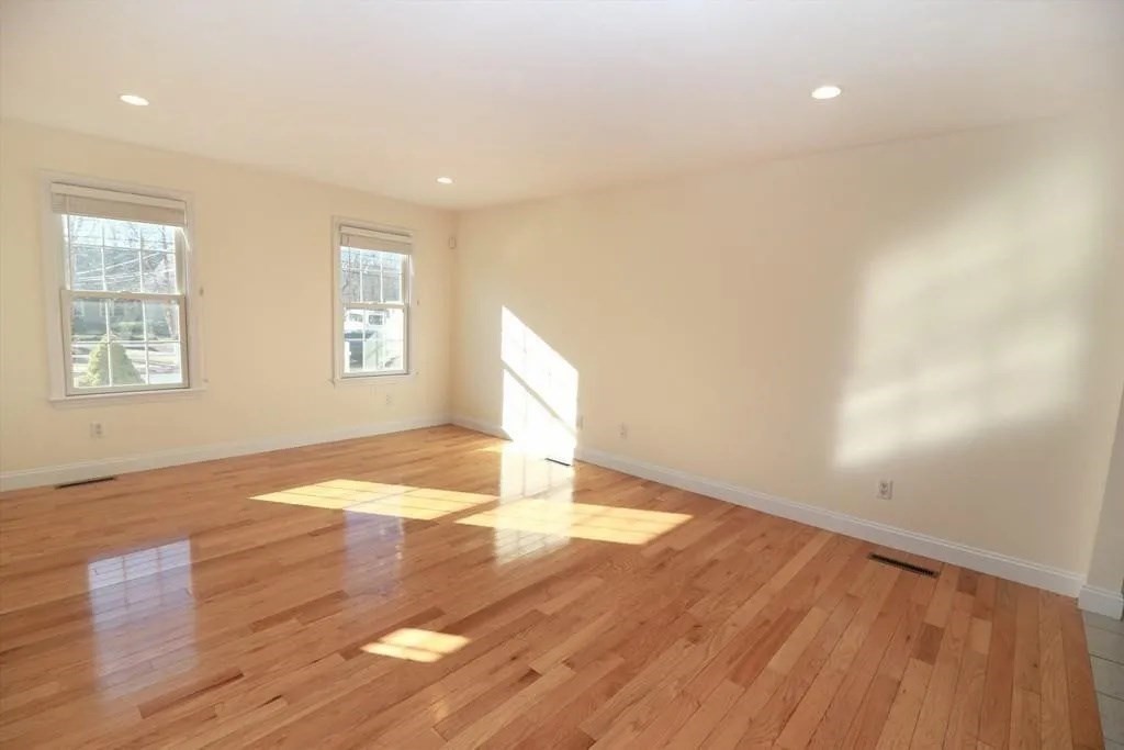 132 Howe Street, Unit B Natick, MA 01760 - Photo 26 of 32 an empty room with wooden floor and windows