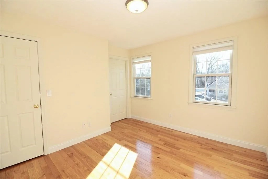 132 Howe Street, Unit B Natick, MA 01760 - Photo 27 of 32 a view of an empty room with wooden floor and a window