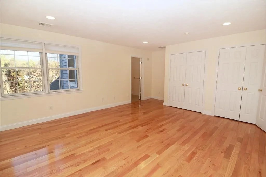 132 Howe Street, Unit B Natick, MA 01760 - Photo 6 of 32 a view of an empty room with wooden floor and a window