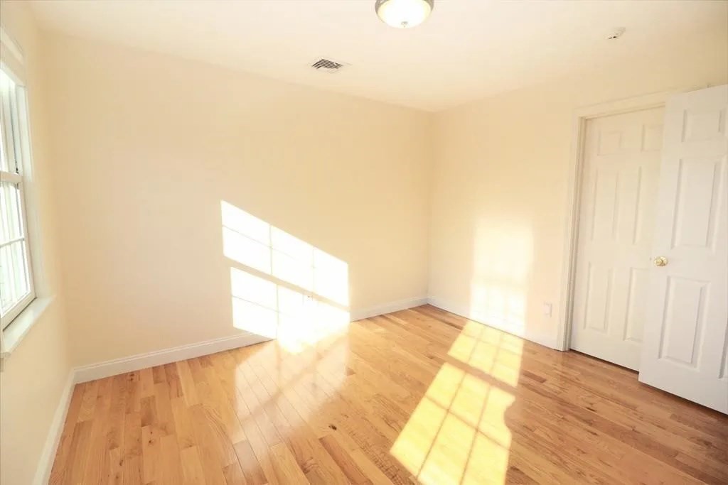 132 Howe Street, Unit B Natick, MA 01760 - Photo 9 of 32 a view of an empty room and wooden floor