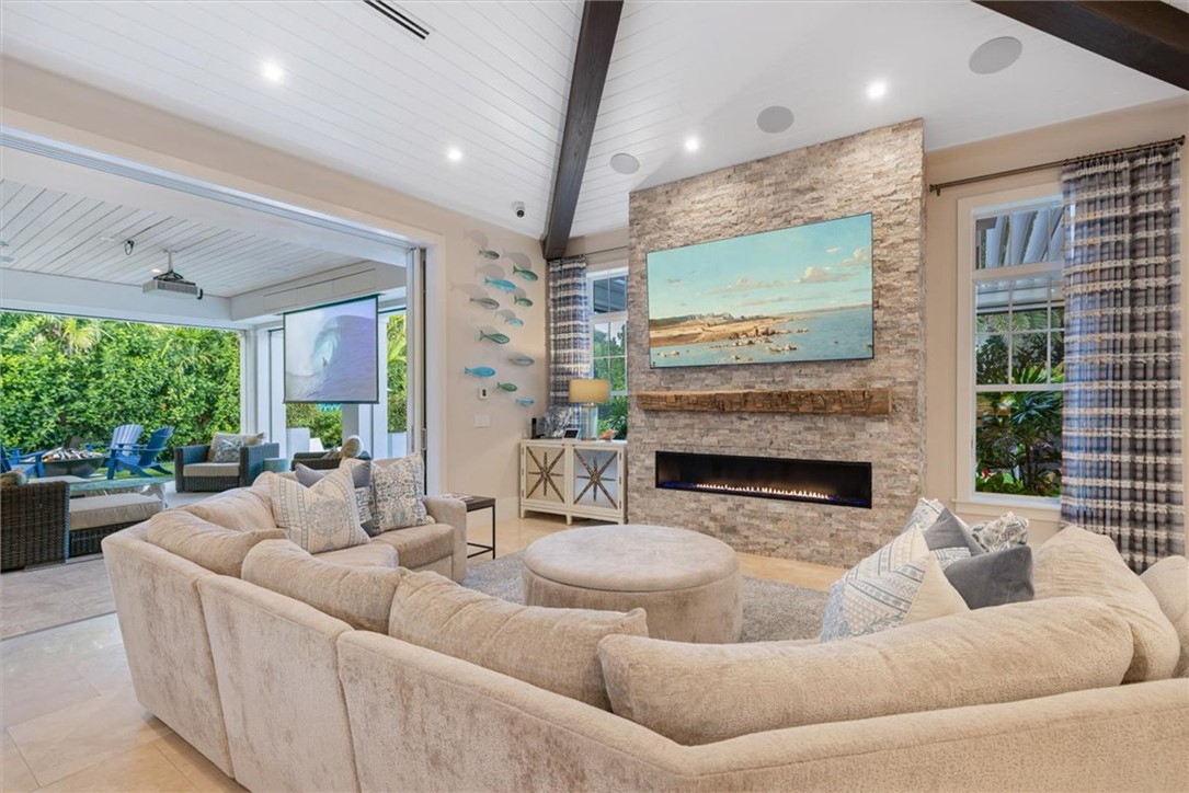 936 Surfsedge Way Vero Beach, FL 32963 - Photo 7 of 36 a living room with furniture a large window and a fireplace