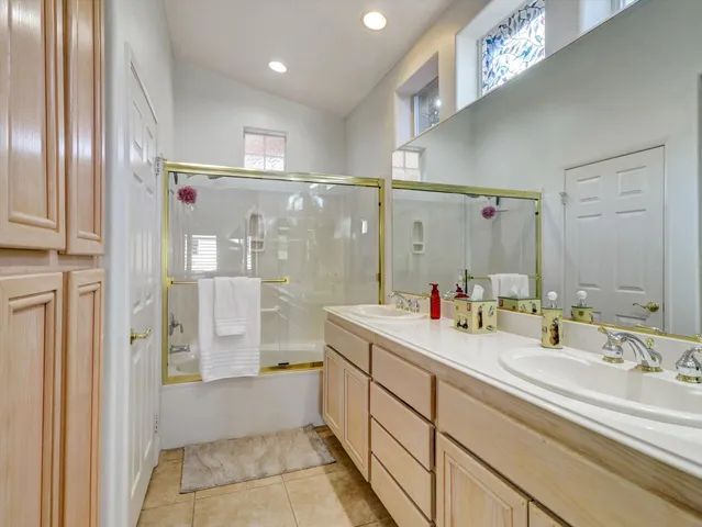a bathroom with a tub sink shower and mirror