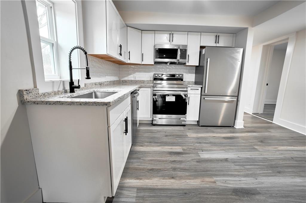 184 Scott Street Northwest Atlanta, GA 30314 - Photo 3 of 29 a kitchen with stainless steel appliances a refrigerator stove and a sink