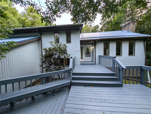 a view of a house with wooden deck and furniture