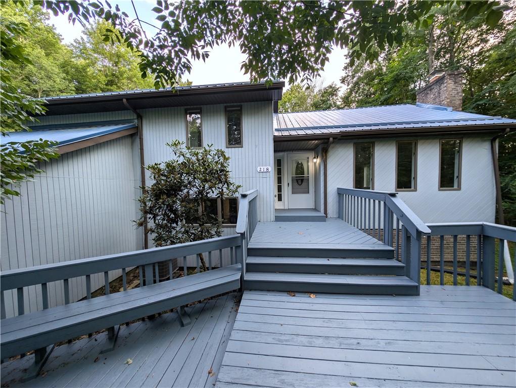 a view of a house with wooden deck and furniture