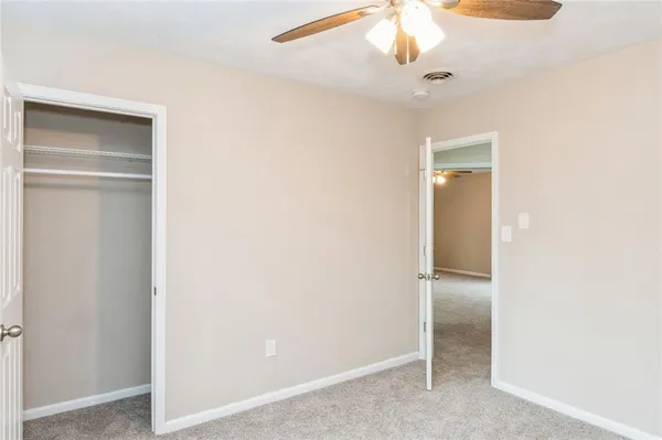 a view of an empty room with a ceiling fan
