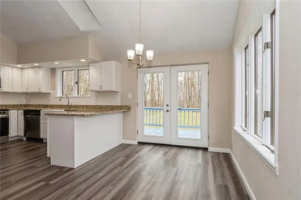 a kitchen with granite countertop white cabinets and white appliances