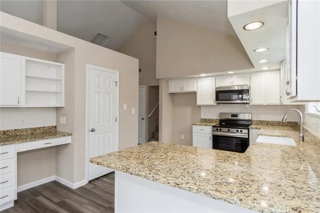 a kitchen with stainless steel appliances granite countertop a stove a sink and a refrigerator