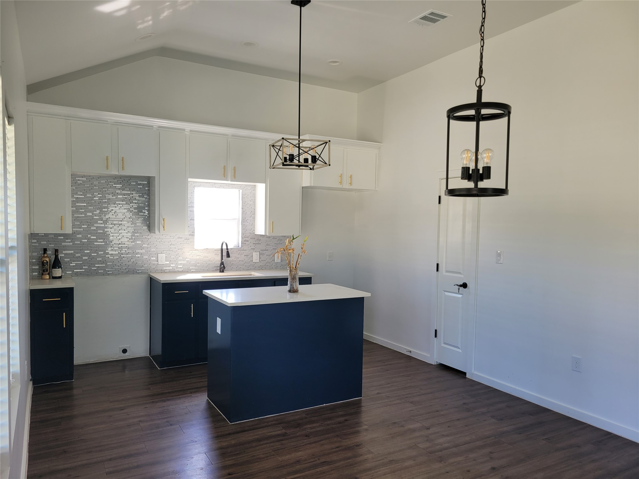 422 A Road Stockdale, TX 78160 - Photo 10 of 40 A contemporary kitchen space boasts high ceilings and stylish dark cabinetry contrasted by white countertops.