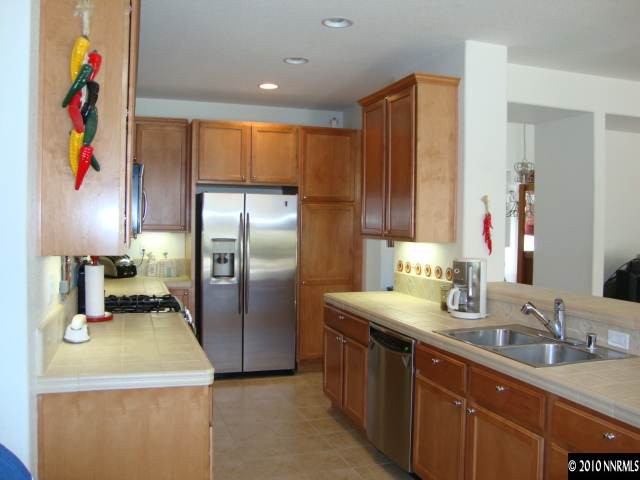 13765 Seabiscuit Drive Reno, NV 89521 - Photo 5 of 9 a kitchen with stainless steel appliances granite countertop a sink refrigerator and microwave