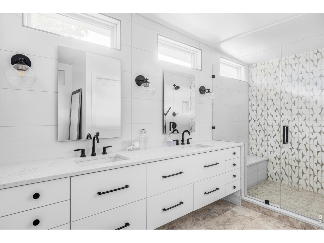 2895 18th Street Boulder, CO 80304 - Photo 21 of 29 The spa-like bathroom features stone flooring, dual sinks, a walk-in shower, and a water closet.