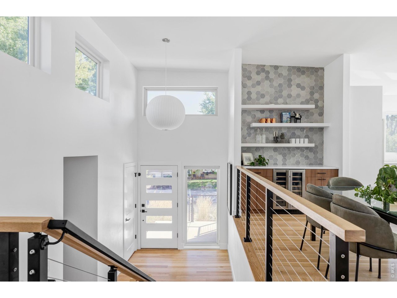 2895 18th Street Boulder, CO 80304 - Photo 7 of 29 A floating staircase leads to the main living areas, where natural light pours through expansive windows and serene treetop vistas provide a calming backdrop throughout the space.