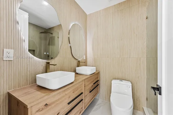 a bathroom with a granite countertop toilet sink and mirror