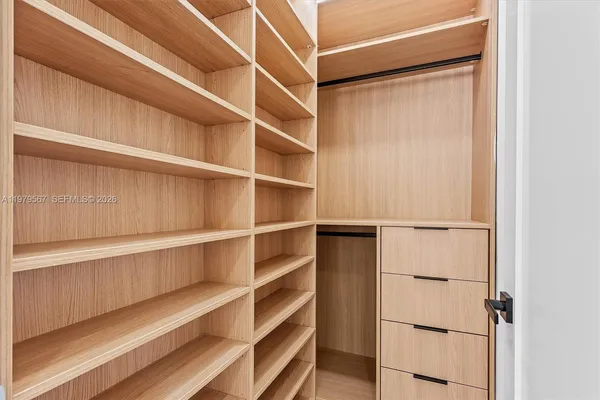a view of walk in closet with empty racks