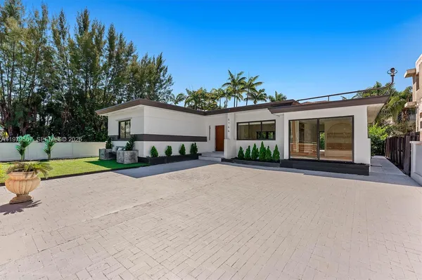 front view of a house with a patio yard and a large tree