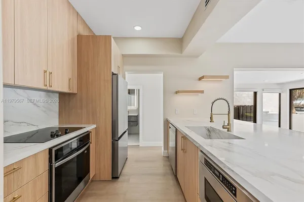 a kitchen with stainless steel appliances granite countertop a sink stove and refrigerator