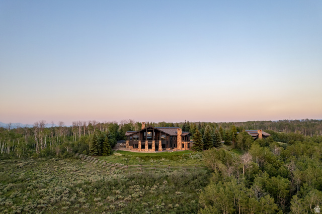 9156 Forest Road, Unit 24 Heber City, UT 84036 - Photo 39 of 42 Stone and timber residence featuring multiple chimneys, a multi-story window facade, and a stone patio