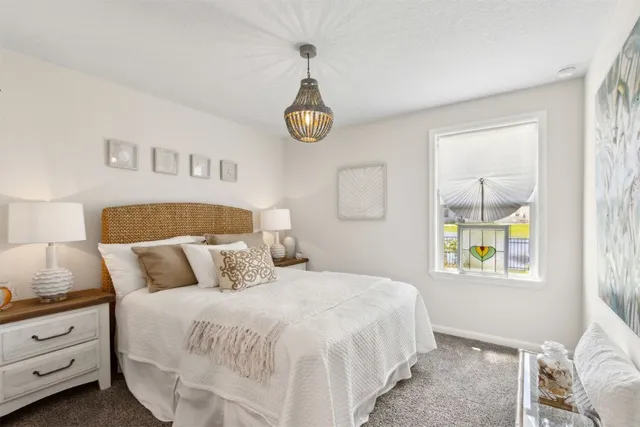 a bedroom with a bed and a painting on the wall