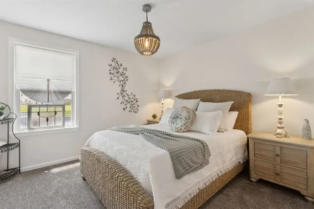 a bedroom with a large bed and a chandelier