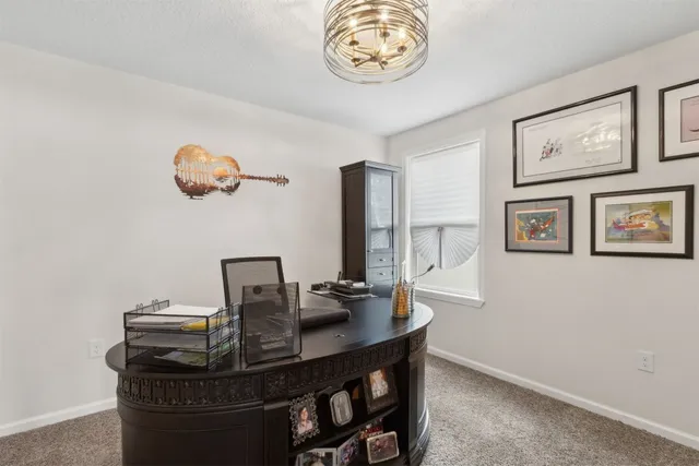 a living room with furniture and paintings on the wall