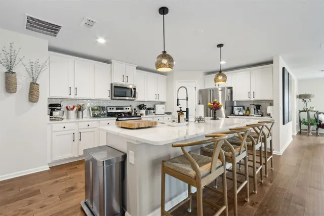 a kitchen with stainless steel appliances granite countertop a sink a stove and a refrigerator