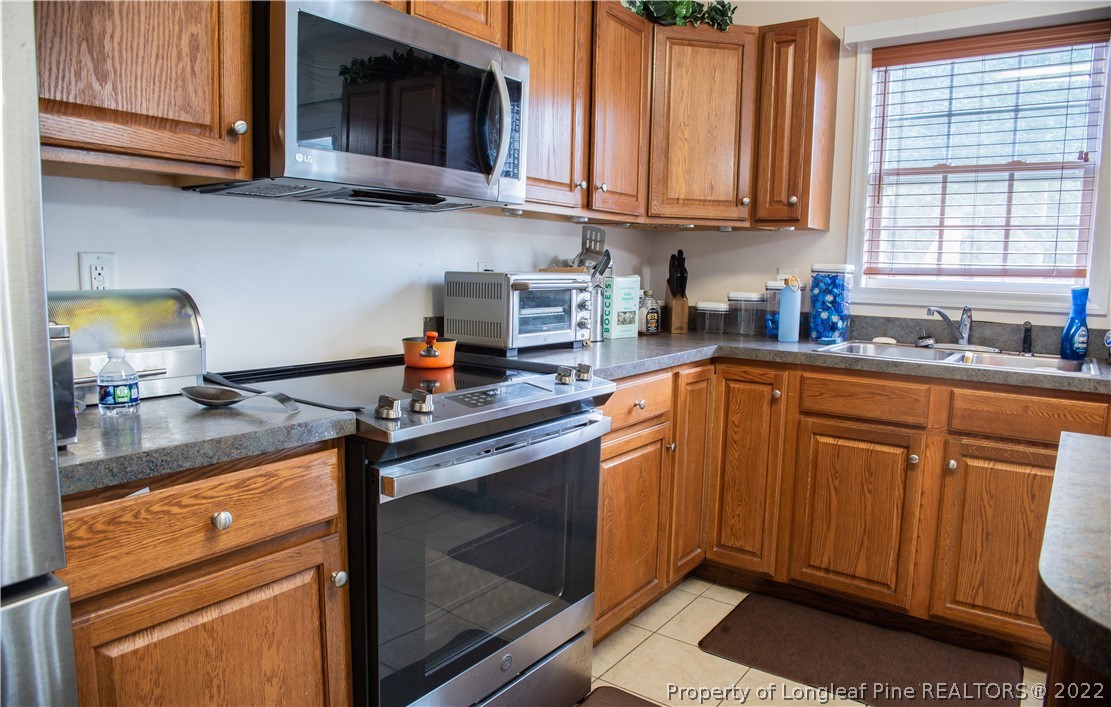 200 Lattimore Road Cameron, NC 28326 - Photo 11 of 32 a kitchen with stainless steel appliances granite countertop a sink stove and cabinets