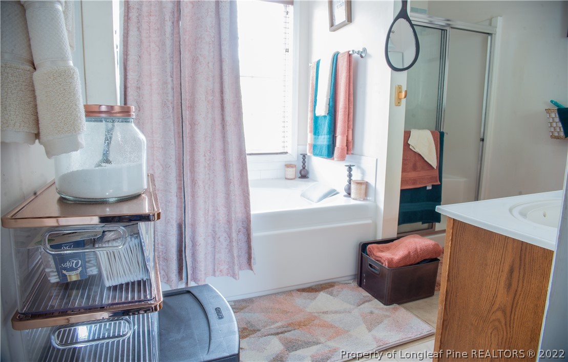 200 Lattimore Road Cameron, NC 28326 - Photo 27 of 32 a bathroom with a bathtub a sink and a mirror