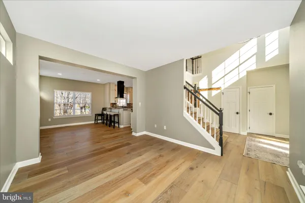 a kitchen with stainless steel appliances granite countertop a refrigerator a oven a sink a dining table and chairs with wooden floor