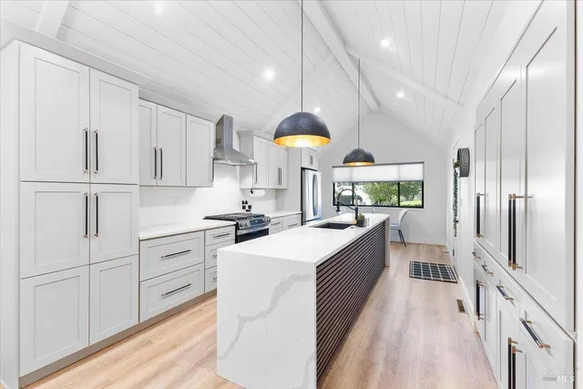 a kitchen with kitchen island white cabinets and stainless steel appliances