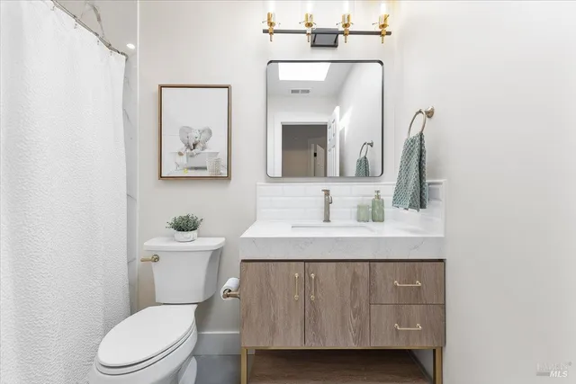 a bathroom with a toilet a sink and mirror