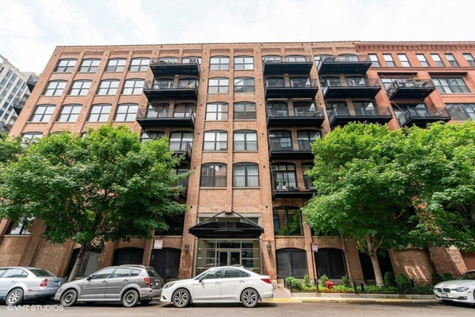 520 West Huron Street, Unit 116 Chicago, IL 60654 - Photo 1 of 28 a front view of a residential apartment building with a yard