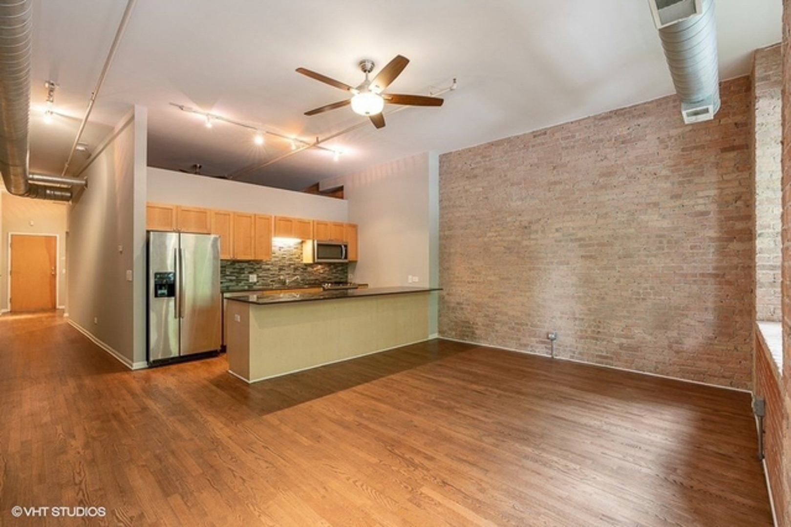 520 West Huron Street, Unit 116 Chicago, IL 60654 - Photo 4 of 28 a view of a kitchen with wooden floor and a ceiling fan