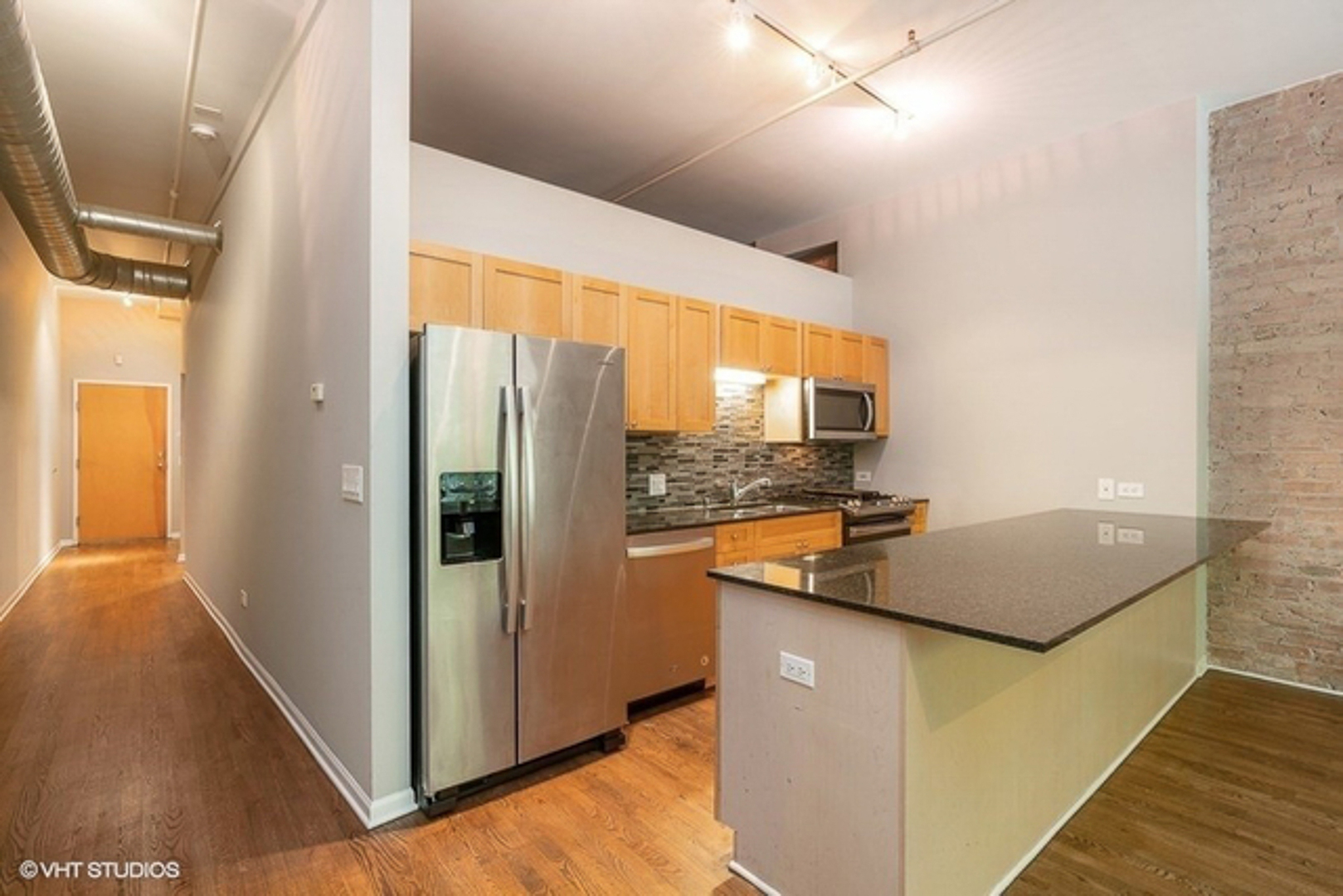 520 West Huron Street, Unit 116 Chicago, IL 60654 - Photo 8 of 28 a kitchen with stainless steel appliances granite countertop a refrigerator a stove and a sink with large window