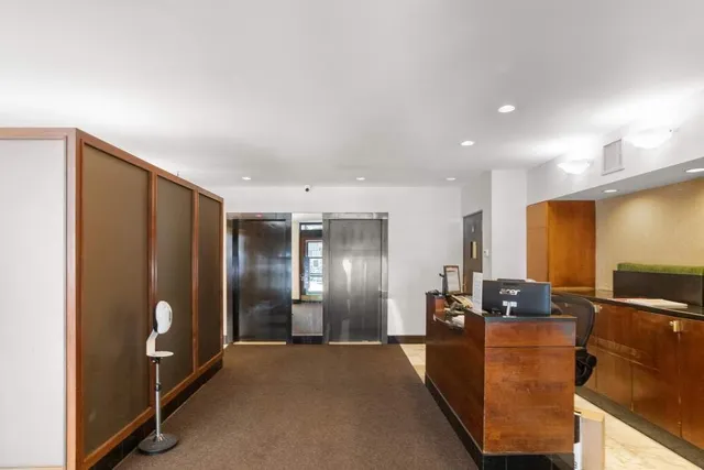 a view of a kitchen with furniture and stainless steel appliances