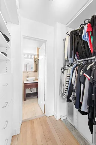 a view of walk in closet with clothes and shoes