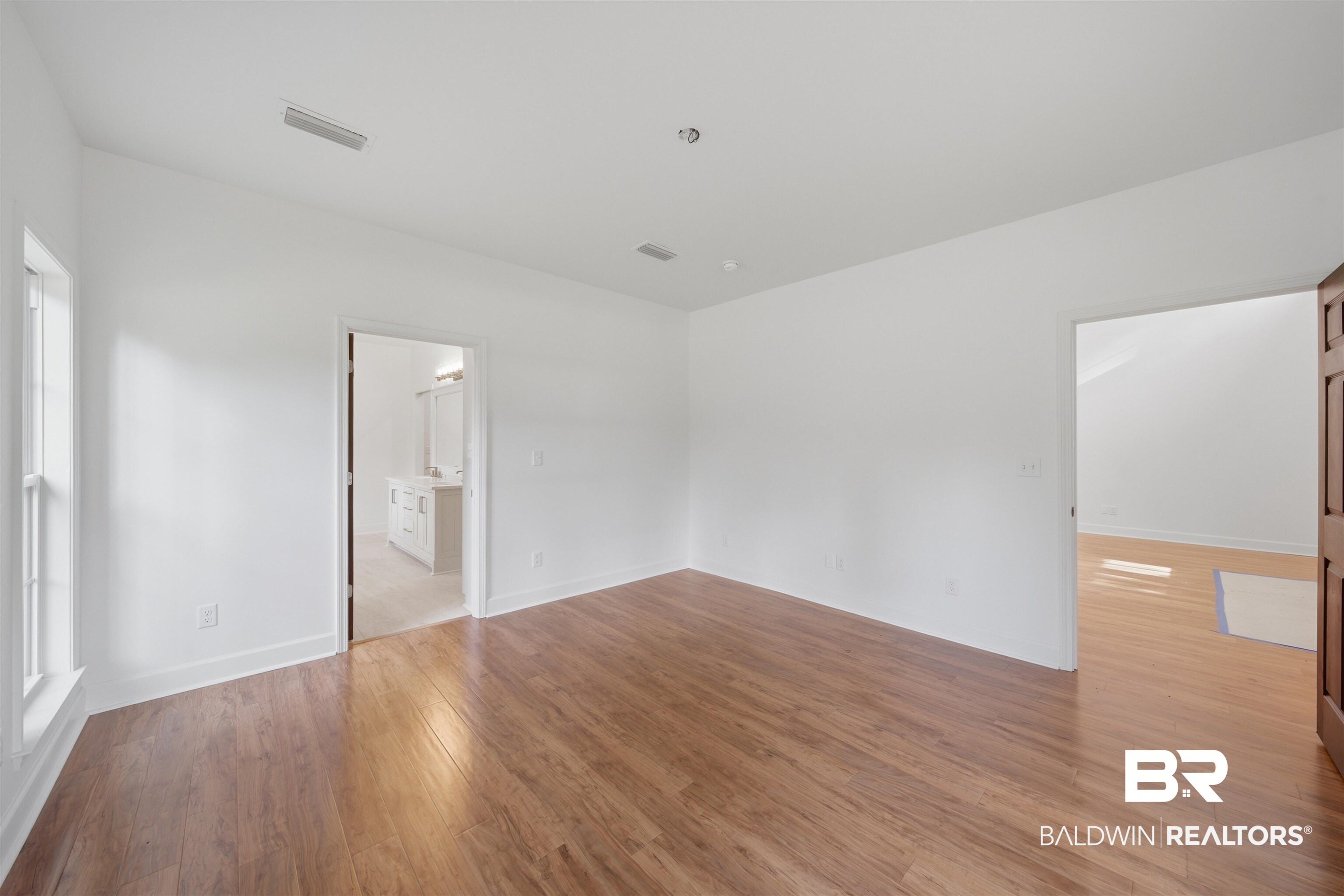 14128 Jackson Lane Foley, AL 36535 - Photo 18 of 36 Bright room featuring wood-finish flooring, white walls, and a window with white trim