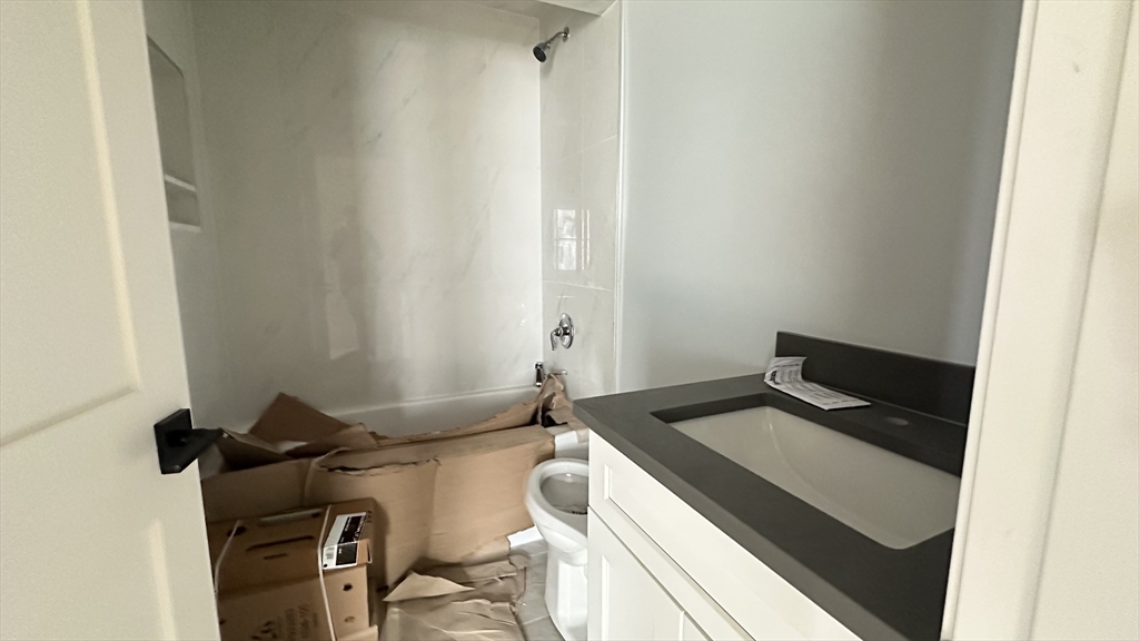 663 Columbia Road, Unit 2 Boston, MA 02125 - Photo 17 of 17 a bathroom with a granite countertop sink and a mirror