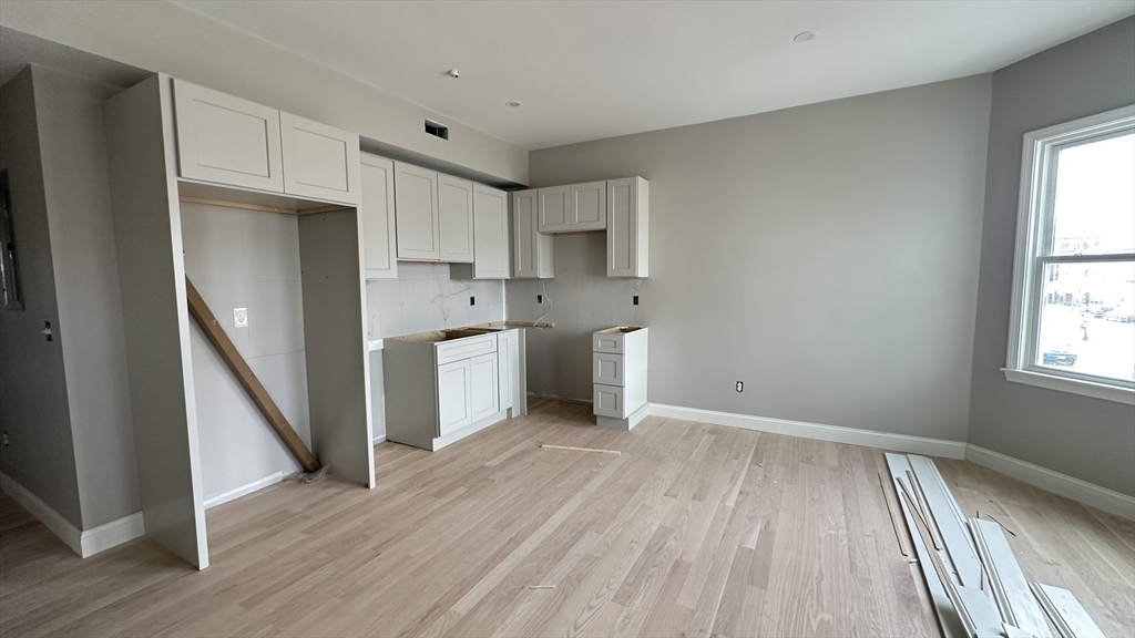 663 Columbia Road, Unit 2 Boston, MA 02125 - Photo 8 of 17 a view of kitchen with wooden floor electronic appliances and window