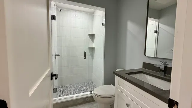 a bathroom with a granite countertop sink toilet and shower
