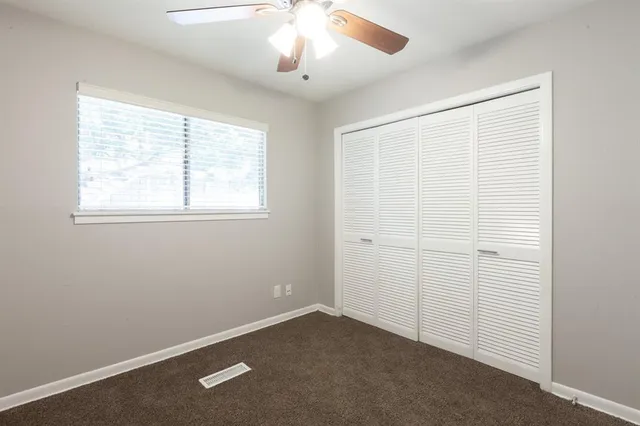 an empty room with windows and closet