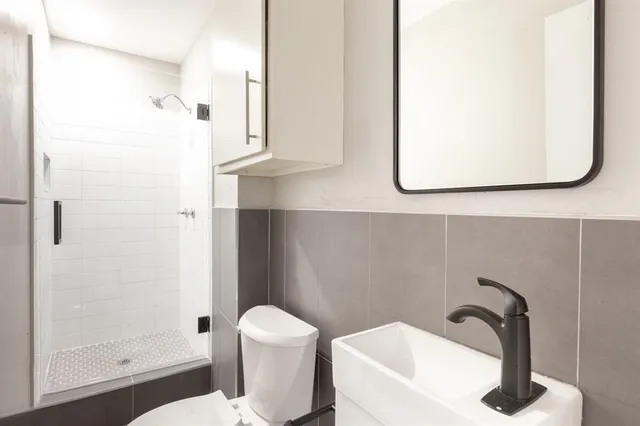 a bathroom with a sink toilet and shower