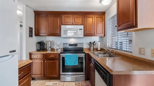 a kitchen with stainless steel appliances granite countertop a sink stove and cabinets