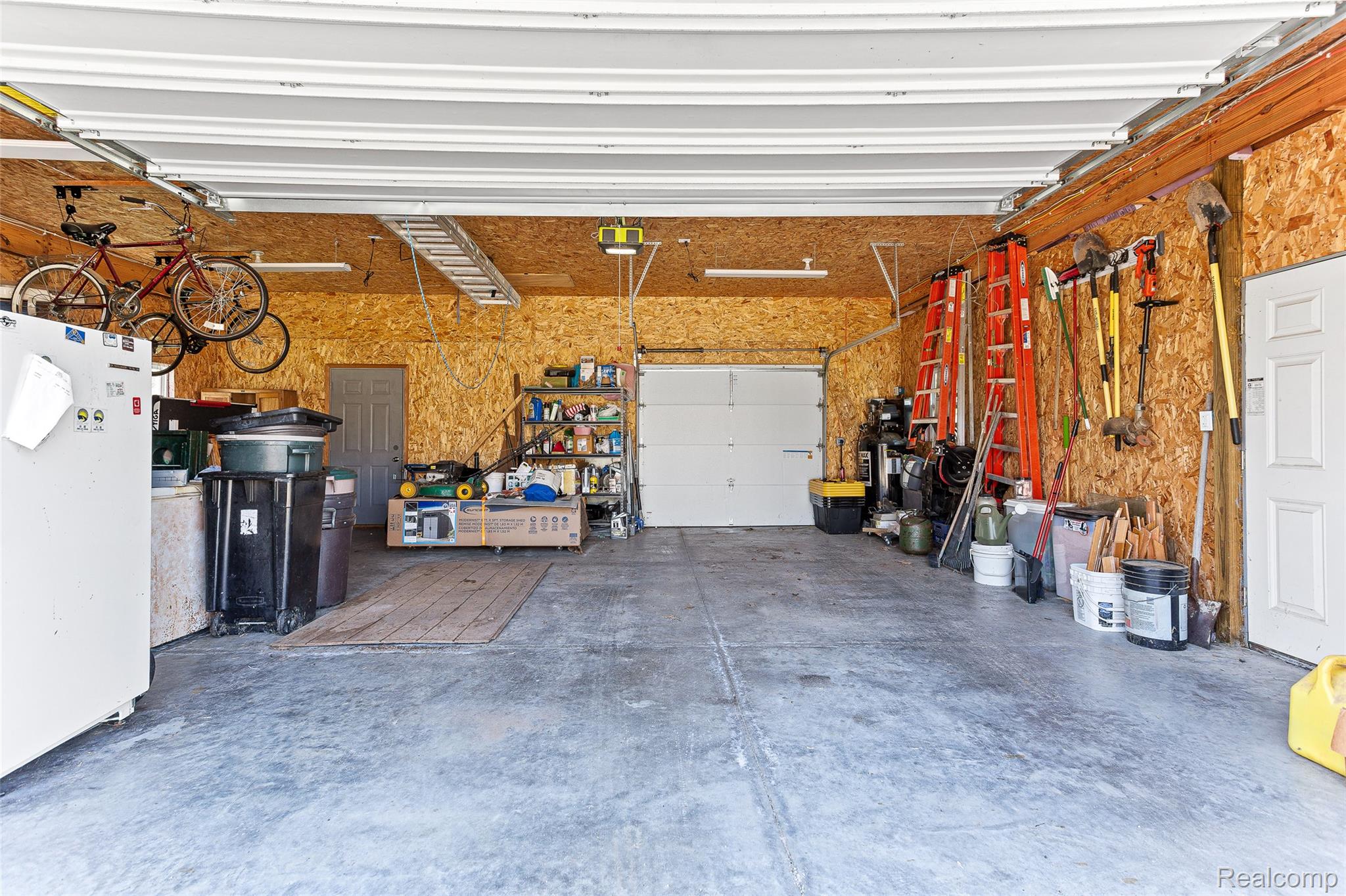 961 Jolly Road Okemos, MI 48864 - Photo 20 of 29 Garage featuring freestanding refrigerator and a garage door opener