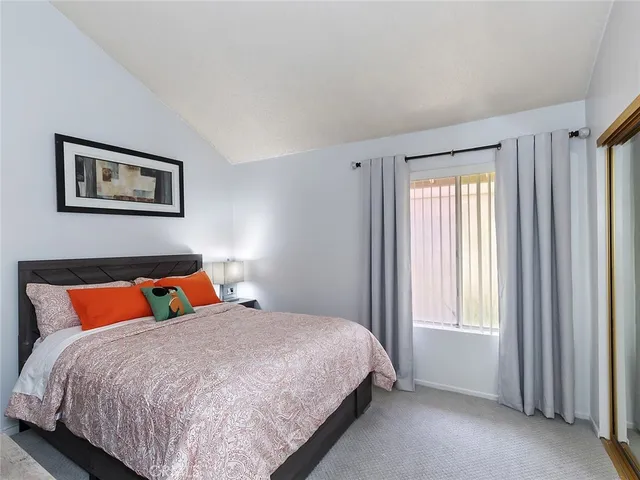 a bed sitting in a bedroom next to a window