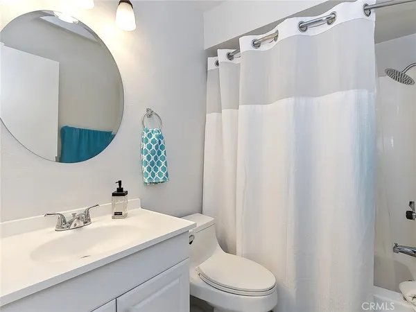 a bathroom with a sink vanity mirror and toilet