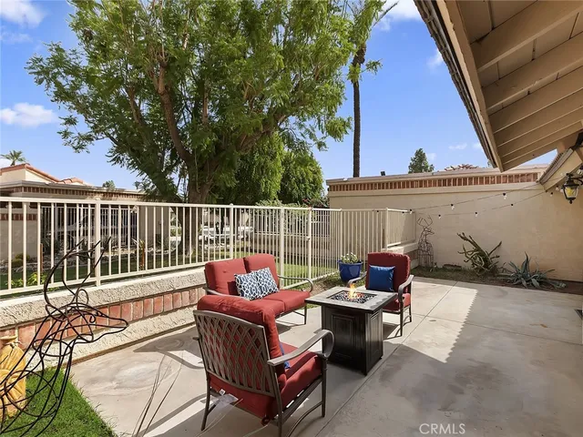 a view of a patio with couches chairs and wooden fence