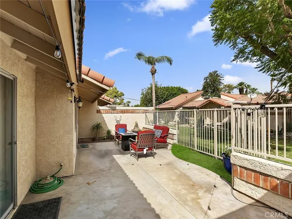 a view of a patio with table and chairs potted plants with wooden floor and fence