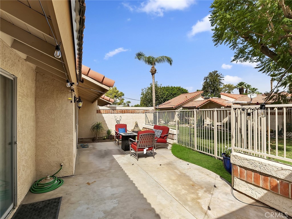 82294 Bergman Drive Indio, CA 92201 - Photo 18 of 22 a view of a patio with table and chairs potted plants with wooden floor and fence