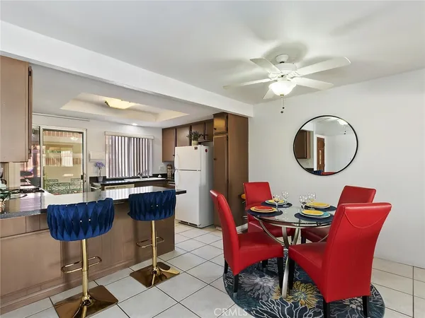a dining room with furniture a rug a potted plant and a chandelier